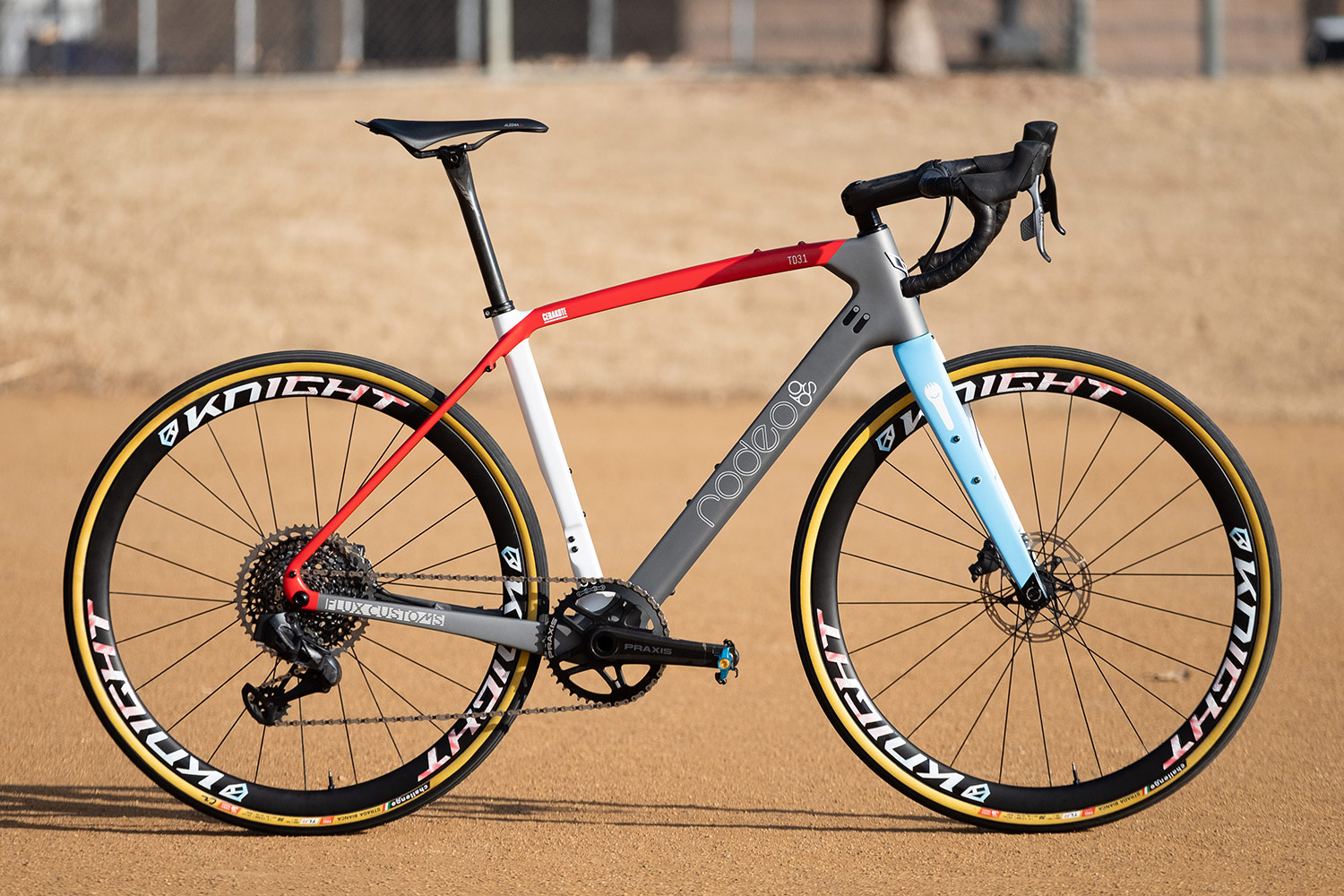 Red, grey, blue, and white custom cerakote Rodeo Labs Traildonkey carbon gravel bike.