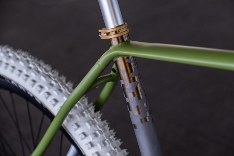 Gold anodized titanium gravel bike with green cerakote paint job and white tires.