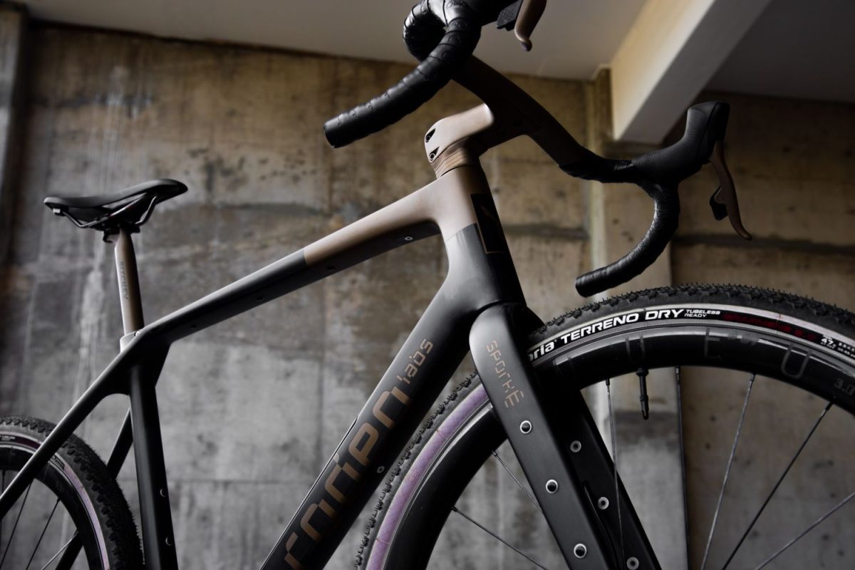Rodeo Labs Traildonkey TD4.2 carbon bike low view of front and side showing the Spork logo and bronze color matching on the stem, top tube, shift levers, and seatpost